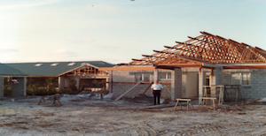 Partially constructed school building with a person standing in front
